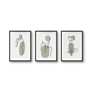 Può includere: Set di tre stampe incorniciate, ognuna con un disegno a tratto nero minimalista di una figura. Le figure sono ambientate su una forma verde tenue su sfondo bianco. Le cornici sono nere, creando un look moderno.