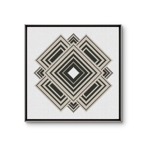 Puede incluir: Una obra de arte geométrica en punto de cruz enmarcada. El diseño presenta formas de diamante superpuestas en negro y beige sobre un fondo blanco. La obra está encerrada en un marco negro, creando una estética moderna.
