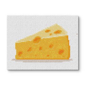 May include: A cross-stitch design of a wedge of cheese. The cheese is yellow with several orange holes. The background is white, and the cheese is sitting on a white surface.