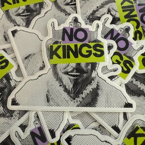 May include: A collection of white stickers with a black and white halftone illustration of a person's face. Each sticker has the words "NO KINGS" in black text on a green and purple background.