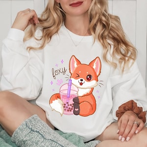 May include: White sweatshirt with a cartoon fox holding a boba tea cup. The text "foxy" is printed on the sweatshirt.