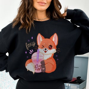 May include: Black sweatshirt with a cartoon fox holding a pink boba tea cup. The text "foxy" is printed on the shirt in a sparkly pink font.
