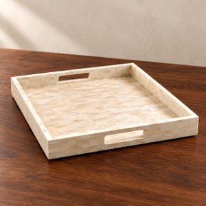 May include: A square serving tray featuring a light beige, mosaic-style tiled surface with a smooth finish. The tray has raised sides and two rectangular cutout handles on opposite ends, constructed from small, rectangular stone-like pieces.