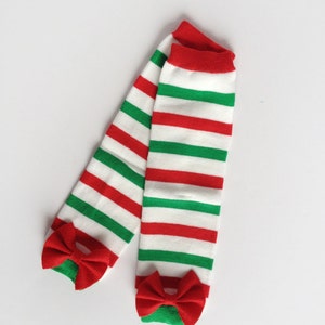 May include: A pair of red and green striped leg warmers with red bows at the bottom.