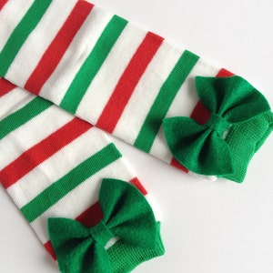 May include: A pair of red, white, and green striped knee-high socks with green bows at the top.