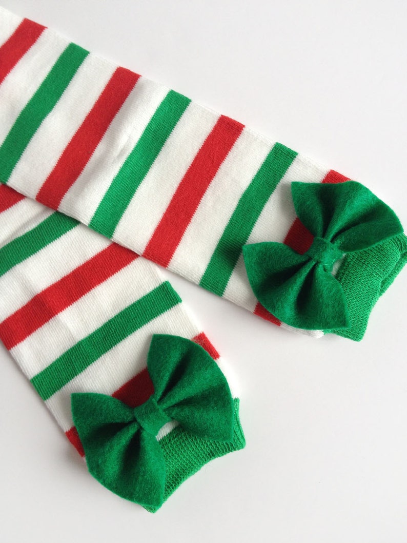 May include: A pair of red, white, and green striped knee-high socks with green bows at the top.