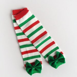 May include: A pair of red and green striped leg warmers with green bows at the bottom.