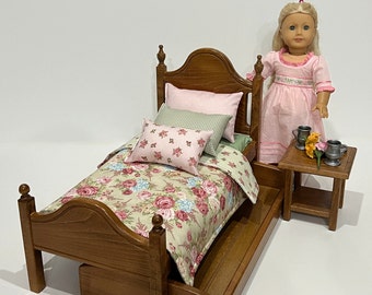 White or stained doll bed with pink, green, and cream bedding. Shipping is included in the price.