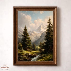 May include: A framed landscape painting of a mountain scene with snow-covered peaks, verdant trees, and a flowing stream. The artwork is rendered in a detailed, realistic style with a warm colour palette, set in a brown wooden frame.