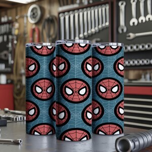 Peut inclure: Trois gobelets en acier inoxydable avec un motif r&eacute;p&eacute;t&eacute; du masque de Spider-Man sur un fond bleu-vert. Le motif pr&eacute;sente le masque en rouge, noir et blanc, avec un motif de toile d'araign&eacute;e. Les gobelets sont cylindriques et ont un bord argent&eacute;.
