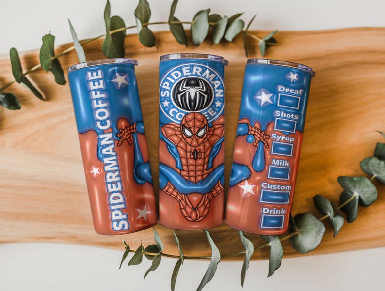May include: Three stainless steel tumblers with a Spider-Man theme. The tumblers are red and blue with the words "Spider-Man Coffee" and a Spider-Man graphic. One tumbler has a coffee customization menu.