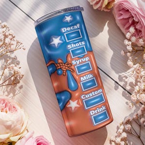 May include: A tall, insulated tumbler with a blue and brown design. The tumbler features a coffee drink customization chart with options for Decaf, Shots, Syrup, Milk, Custom, and Drink. White stars and a decorative design are also visible.