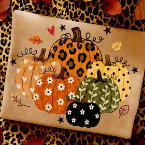May include: A rectangular tan surface featuring a painted illustration of five pumpkins. The pumpkins display various patterns including leopard print, white hearts, white daisies, black polka dots, and white vines, accented by small stars and leaves.
