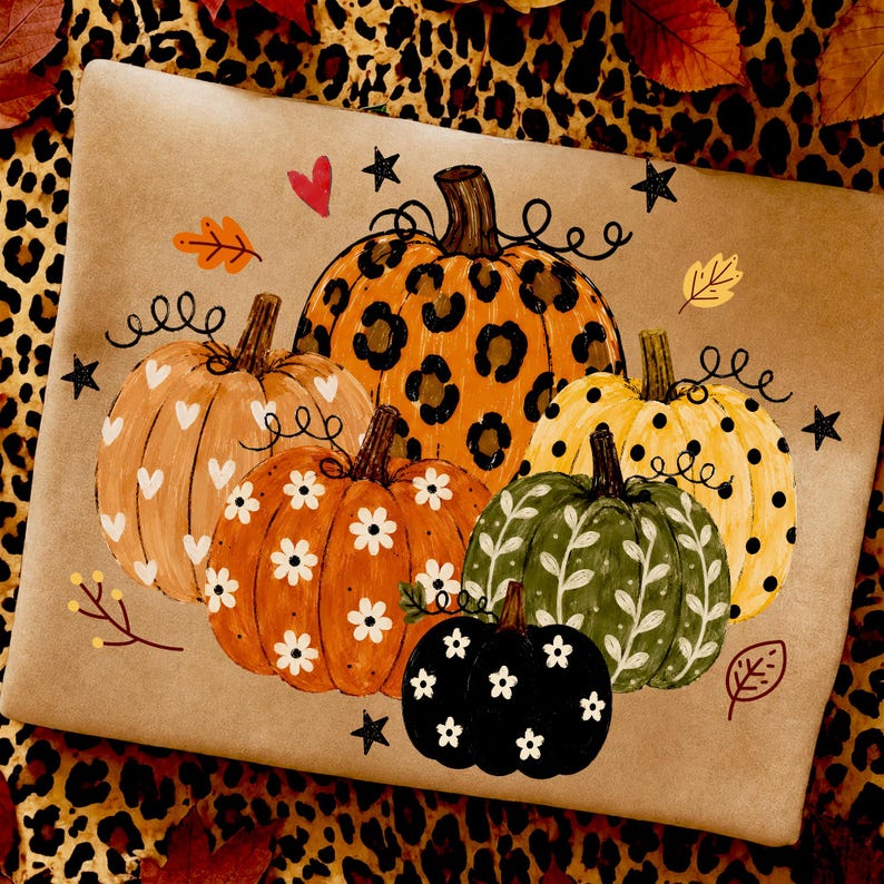 May include: A rectangular tan surface featuring a painted illustration of five pumpkins. The pumpkins display various patterns including leopard print, white hearts, white daisies, black polka dots, and white vines, accented by small stars and leaves.