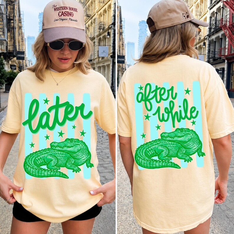 May include: A light yellow t-shirt with a green alligator graphic and the word "later" in green script. The back of the shirt has the words "after while" and another alligator graphic. The shirt also has blue stripes and green stars.