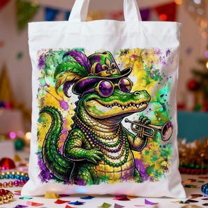 May include: White tote bag featuring a cartoon alligator in a purple and green hat, sunglasses, and a beaded necklace. The alligator is playing a trumpet against a colorful, splattered background.
