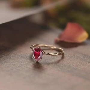 May include: A white ceramic mug with a black handle and the text "But First, Coffee" in a bold, black font. The mug is set against a blurred background, suggesting a cozy setting.