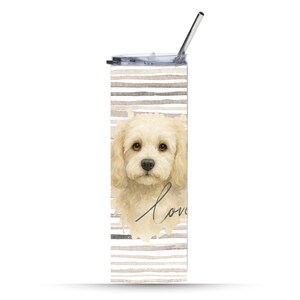 May include: A tall, insulated tumbler with a dog portrait and the word "love." The tumbler features a light beige and gray striped background. It includes a clear lid and a silver straw.