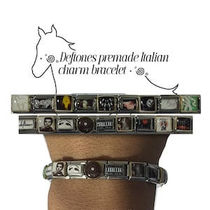 Op de afbeelding: Een zilverkleurige Italiaanse bedelarmband bestaande uit een reeks vierkante schakels met diverse Deftones-thema grafische prints, waaronder albumhoezen en bandafbeeldingen. De armband wordt plat weergegeven en om een pols gedragen.