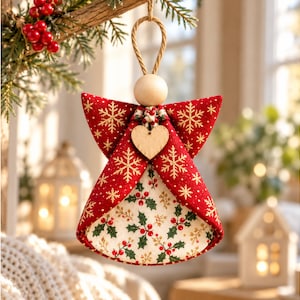 May include: A hanging angel ornament featuring a red fabric body with gold snowflake patterns and a cream-colored fabric interior decorated with green holly leaves and red berries. A plain wooden bead serves as the head, and a small wooden heart is attached.