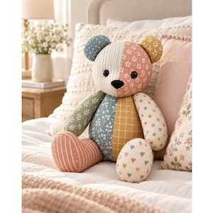 Könnte beinhalten: Ein Patchwork-Teddybär aus verschiedenen Stoffmustern wie Streifen, Blumenprints, Punkten und Karomustern in gedeckten Blau-, Rosa-, Grün- und Gelbtönen, ausgestattet mit schwarzen Knopfaugen und einer schwarzen Knopf-Nase.