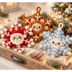 May include: Three crocheted snowflake ornaments with smiling faces and rosy cheeks. One is red and white with a Santa Claus design, one is brown and white, and one is light blue and white. Each has a loop at the top for hanging as a decoration.