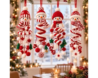 May include: Four hanging crochet snowman ornaments featuring red and white striped hats and scarves. Each snowman is attached to a red and white spiral base adorned with small crocheted elements including mittens, stars, snowflakes, and trees.