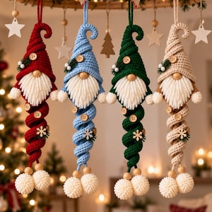 May include: Four hanging crochet gnome ornaments in red, light blue, dark green, and beige. Each gnome features a tall pointed hat, a round wooden nose, a white yarn beard, and a long spiraling body decorated with wooden buttons and snowflakes.