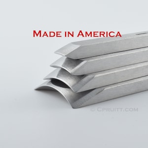 May include: A set of five silver metal chisels stacked on top of each other. The chisels are all different sizes and shapes. The text "MADE IN AMERICA" is printed in red above the chisels.
