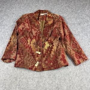 May include: A long-sleeve blazer featuring a textured, woven pattern in shades of deep red, burnt orange, and gold. The garment includes a notched lapel, a solid brown interior lining, and two light-colored, toggle-style buttons on the front.