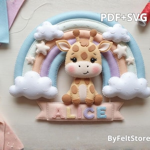 Pode incluir: Uma girafa de feltro senta-se sob um arco-íris pastel com nuvens brancas e estrelas. A girafa é bege com manchas marrons. Uma faixa abaixo da girafa soletra "ALICE" em letras coloridas. O texto "PDF+SVG" é visível.