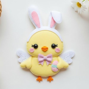 May include: A yellow felt chick wearing a bunny ear headband, holding a decorated Easter egg, and wearing a pink bow tie. The chick is surrounded by baskets of colorful eggs and flowers, and a pair of purple scissors.