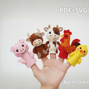 Può includere: Una mano che mostra cinque burattini a dito in feltro: un maiale rosa, una mucca marrone, una mucca bianca e marrone, un gallo rosso e un pulcino giallo. I burattini sono fatti a mano e presentano espressioni facciali dettagliate. Il testo sull'immagine recita "PDF+SVG" e "ByFeltStore".
