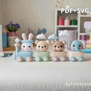 Peut inclure: Un train jouet en feutre avec un lapin, deux ours et un éléphant. Le train est bleu clair avec des roues beiges. Chaque animal a un visage souriant et se trouve dans un wagon de couleur différente. Le texte "PDF+SVG" est en haut à droite.