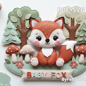Pode incluir: Uma cena de floresta em feltro com uma raposa laranja com detalhes brancos, rodeada por árvores, cogumelos e flores. A faixa diz "BABY FOX" em cores pastel. O design é caprichoso e feito à mão.