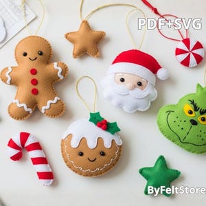 May include: A collection of felt Christmas ornaments in various shapes, including a gingerbread man, star, Santa Claus, Grinch, candy cane, and a Christmas pudding. Each ornament has a gold string for hanging. The ornaments are in shades of brown, red, green, and white.