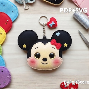 Pode incluir: Chaveiro Minnie Mouse de feltro preto com laço vermelho, corações e estrelas. O chaveiro tem um anel e uma corrente de metal. A imagem também mostra formas de feltro coloridas e o texto "PDF+SVG" e "ByFeltStore".