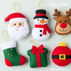 Pode incluir: Uma coleção de enfeites de Natal de feltro em várias formas. Inclui um Papai Noel, um boneco de neve, uma rena, uma meia, um presente e uma bola vermelha. Cada enfeite tem um fio dourado para pendurar. O texto "PDF + SVG" é visível.