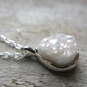 This is a sparkly white druzy necklace. It's a minimalist pendant with some hints of pink when it hits the light. A great present for friends or yourself.