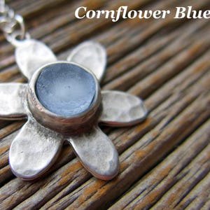 Handmade sea glass flower pendant necklace with aqua blue and other colours in a cabochon in a five-petal silver setting on a silver chain.
