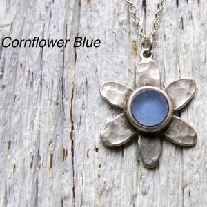 Handmade sea glass flower pendant necklace with aqua blue and other colours in a cabochon in a five-petal silver setting on a silver chain.
