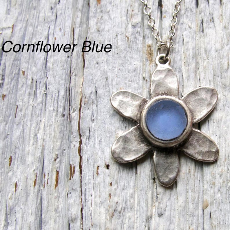 Handmade sea glass flower pendant necklace with aqua blue and other colours in a cabochon in a five-petal silver setting on a silver chain.