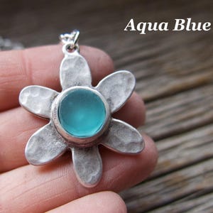 Handmade sea glass flower pendant necklace with aqua blue and other colours in a cabochon in a five-petal silver setting on a silver chain.