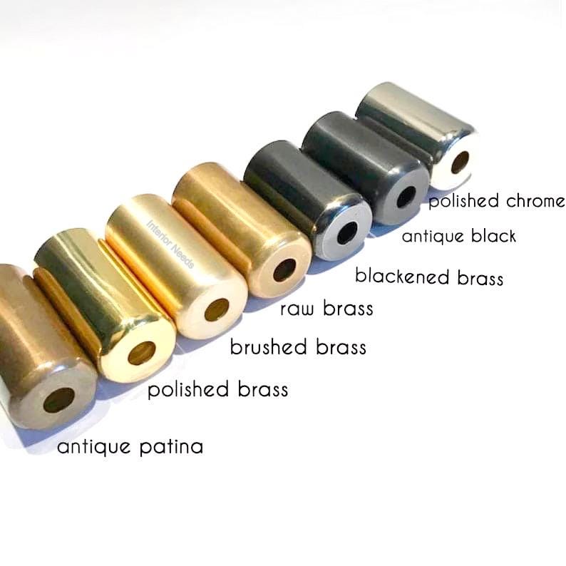 May include: An assortment of cylindrical metal objects in various finishes, including polished chrome, antique black, and antique patina. The text labels each finish: polished chrome, antique black, blackened brass, raw brass, brushed brass, polished brass, and antique patina.