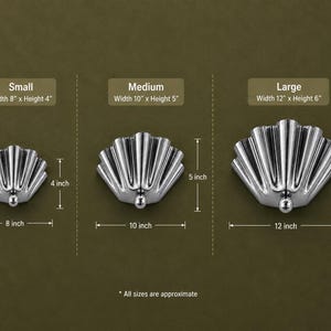 Peut inclure: Trois objets en forme de coquillage argentés en tailles petite, moyenne et grande. Le petit mesure 20,32 cm de large sur 10,16 cm de haut, le moyen 25,4 cm sur 12,7 cm, et le grand 30,48 cm sur 15,24 cm.
