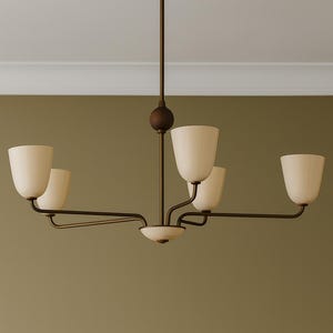 May include: A five-light chandelier featuring a dark bronze metal frame with a central vertical rod, a spherical accent, and curved arms. The fixture includes five upward-facing off-white glass shades and one downward-facing glass bowl.