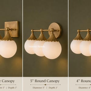 Puede incluir: Tres apliques de pared de lat&oacute;n con globes de vidrio esmerilado blanco y tapas met&aacute;licas estriadas. Las opciones incluyen una base cuadrada de 12,7 cm, una base redonda de 12,7 cm o 10,16 cm. Cada l&aacute;mpara tiene una barra horizontal con tres luces.