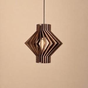 May include: A pendant light fixture featuring a dark brown wooden frame constructed from vertical slats arranged in a geometric, diamond-like shape. A single exposed filament light bulb is visible inside the center of the wooden structure.