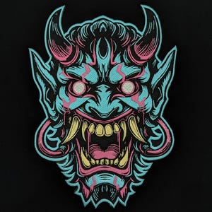 Peut inclure: Écusson brodé représentant un masque Oni. Le masque est de couleur turquoise avec des détails roses et jaunes, notamment des cornes et des crocs. Le patch est posé sur un fond noir. Le design est très détaillé.