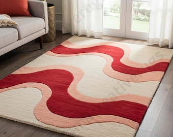 May include: A rectangular area rug with a wavy design in shades of red, pink, and cream. The rug's pattern features flowing, organic shapes, creating a visually dynamic and modern aesthetic. The rug is placed on a hardwood floor.